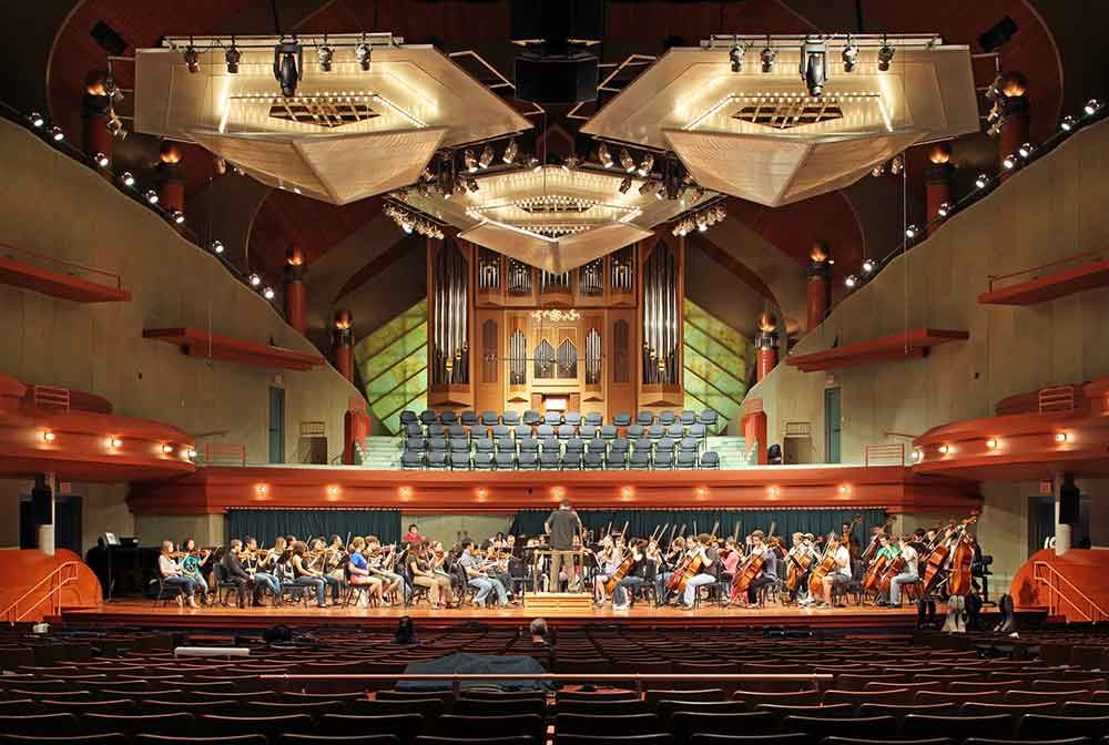 A large orchestra is playing in a large auditorium