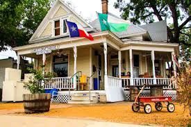 A house with a porch and a red wagon in front of it.