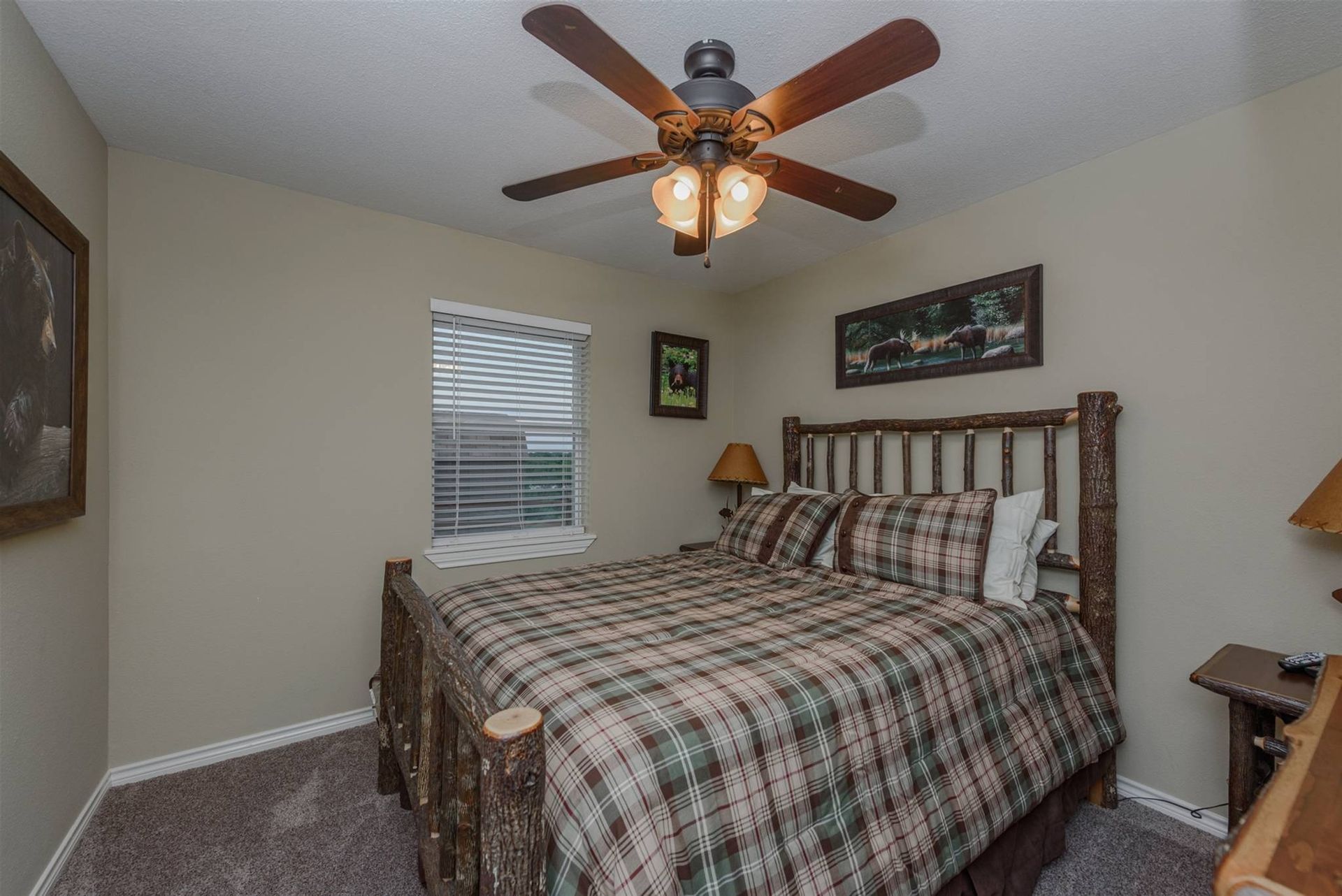 A bedroom with a king size bed and a ceiling fan.