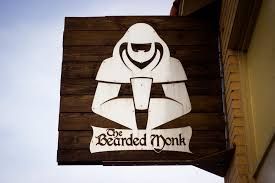 A sign for the bearded monk is hanging from a building.