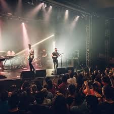 A group of people are standing on a stage in front of a crowd.