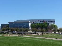 A large building with a lot of windows is surrounded by grass and trees.