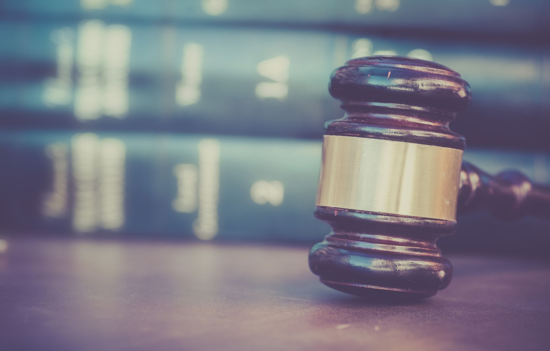 Gavel resting on a table with law books in the background.