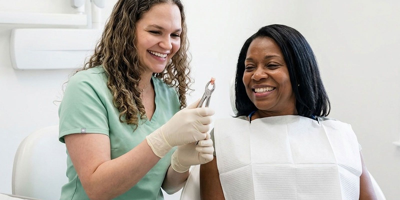 Dr. Stephanie Sfiroudis DDS, MS shows her female patient the results of her tooth extraction