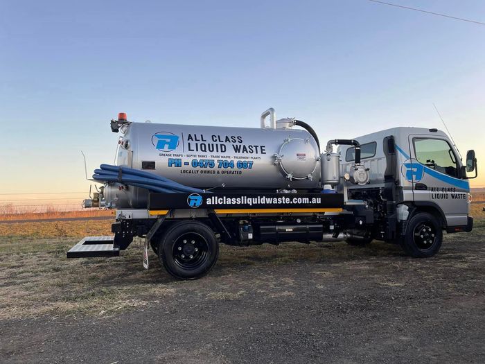 Silver Liquid Waste Truck With Blue Logo Parked Outdoors at Dusk — All Class Liquid Waste in Oakey, QLD