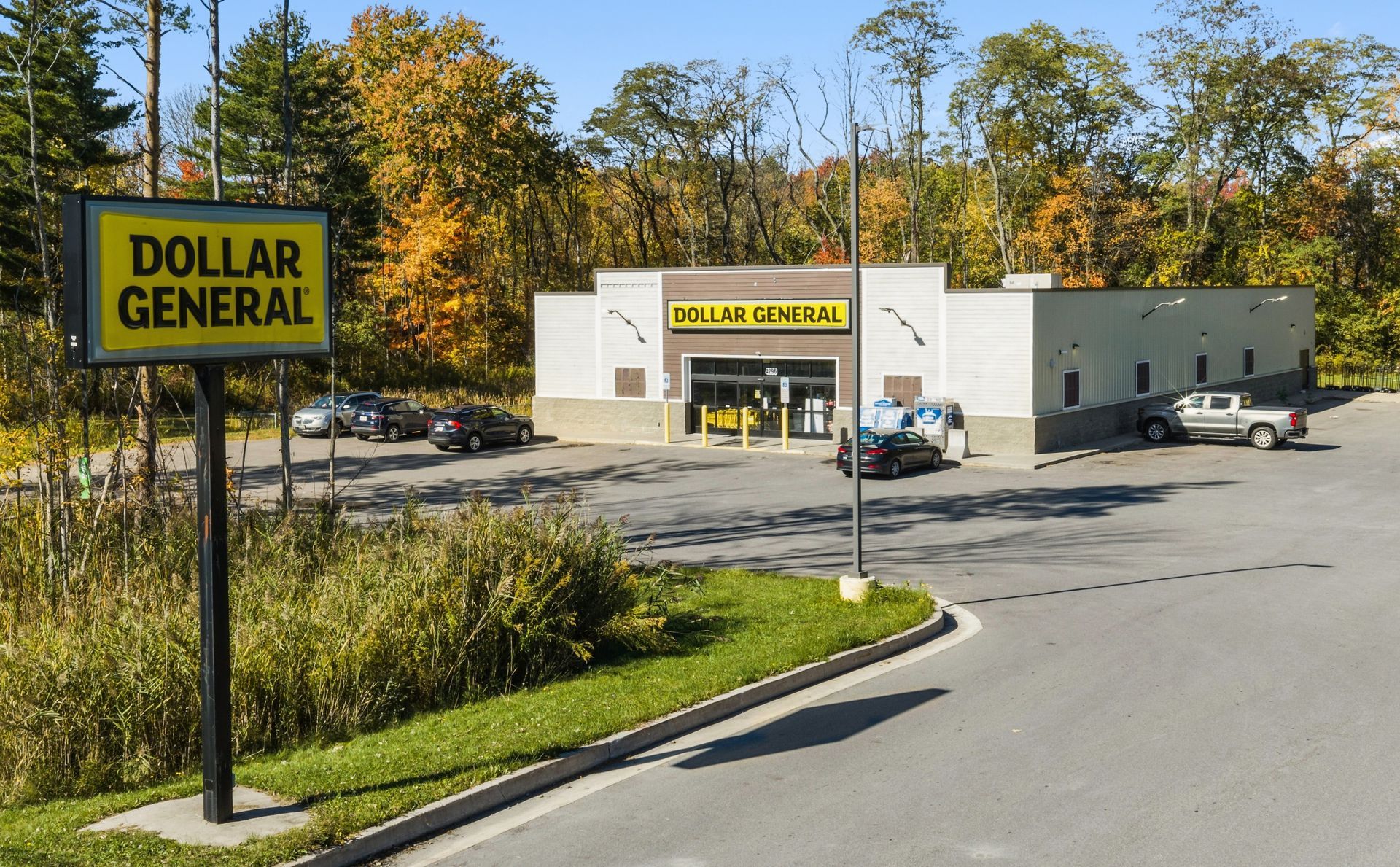 Dollar General store and sign beside a parking lot on a sunny day