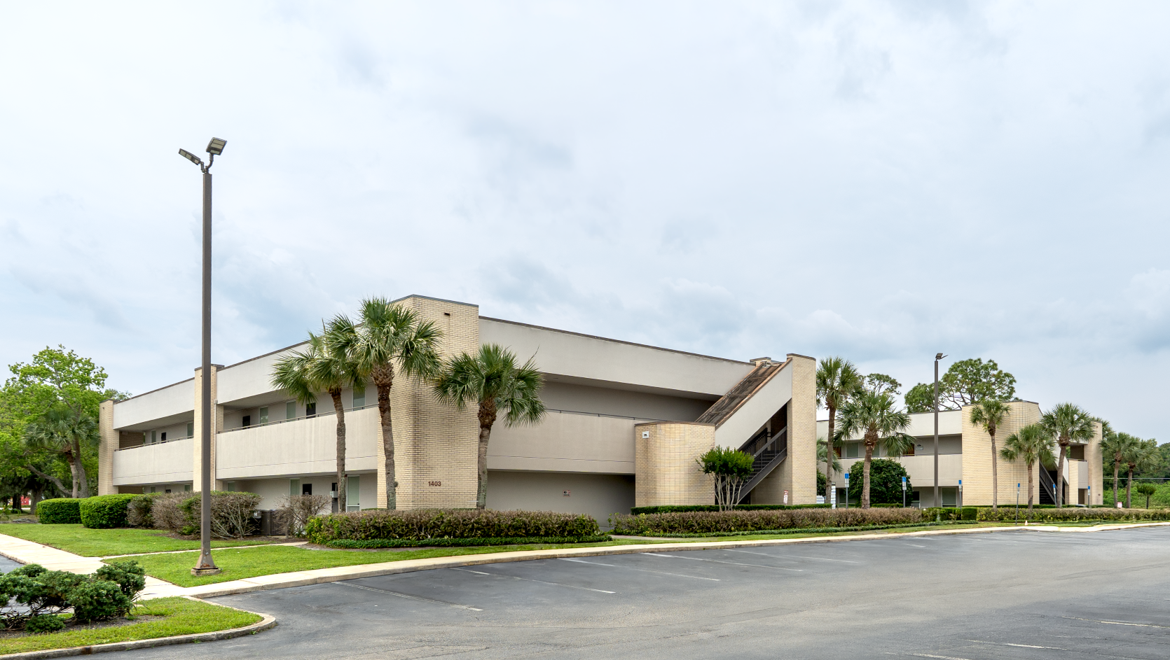 Street view of Pediatric Associates entrance into Central Florida Medical Arts Center building with palm trees and parking lot under cloudy sky