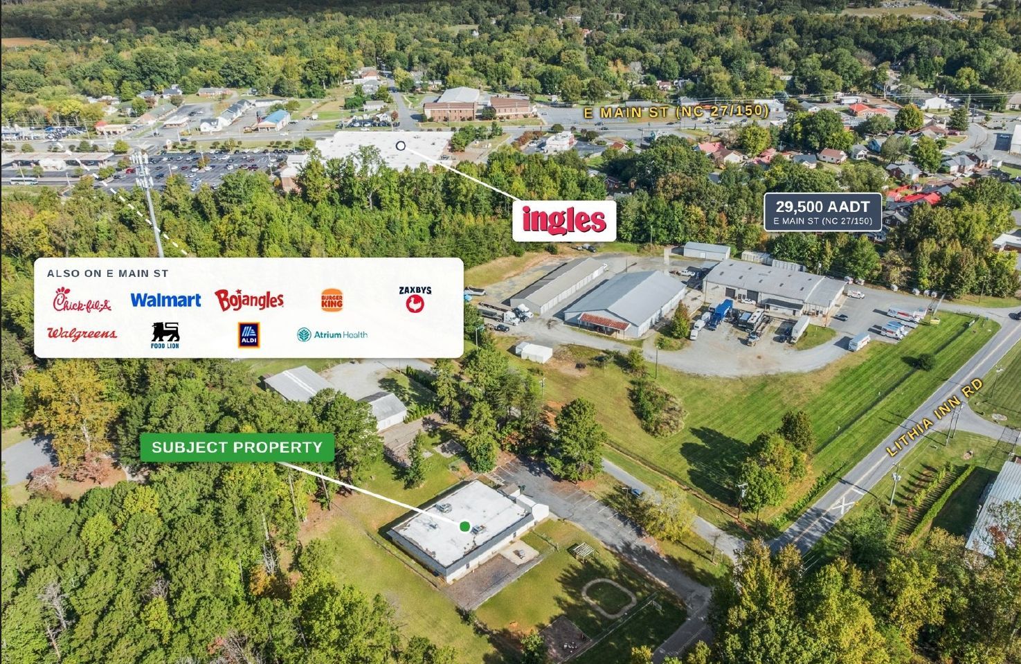 Aerial view of an Ingles supermarket and nearby store signs beside a wooded area and parking lot.