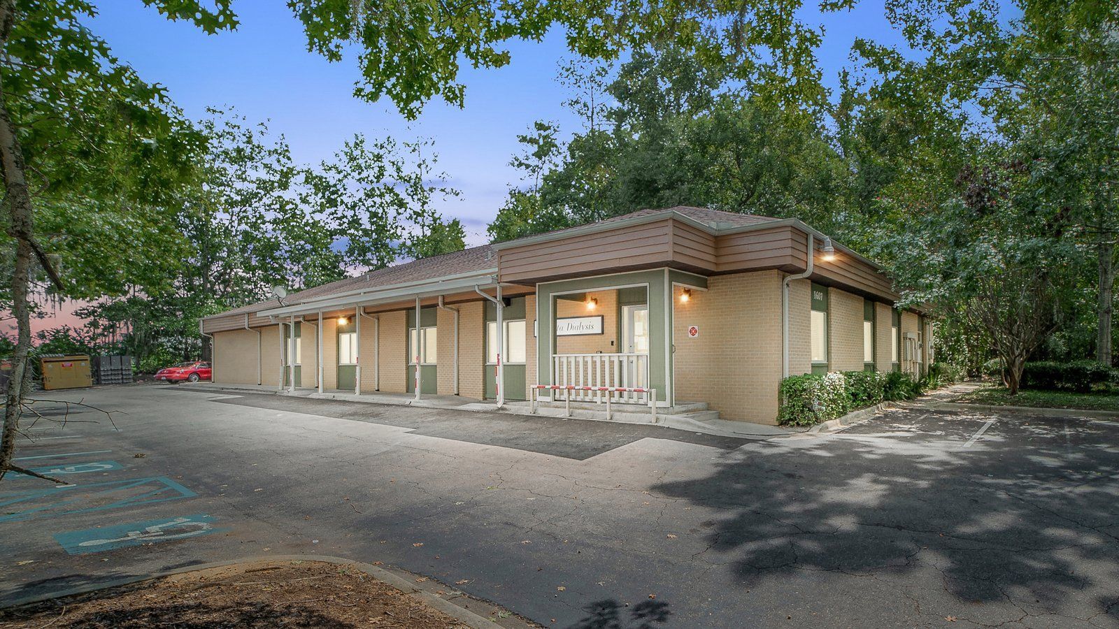 A large brick building with a lot of windows is surrounded by trees.