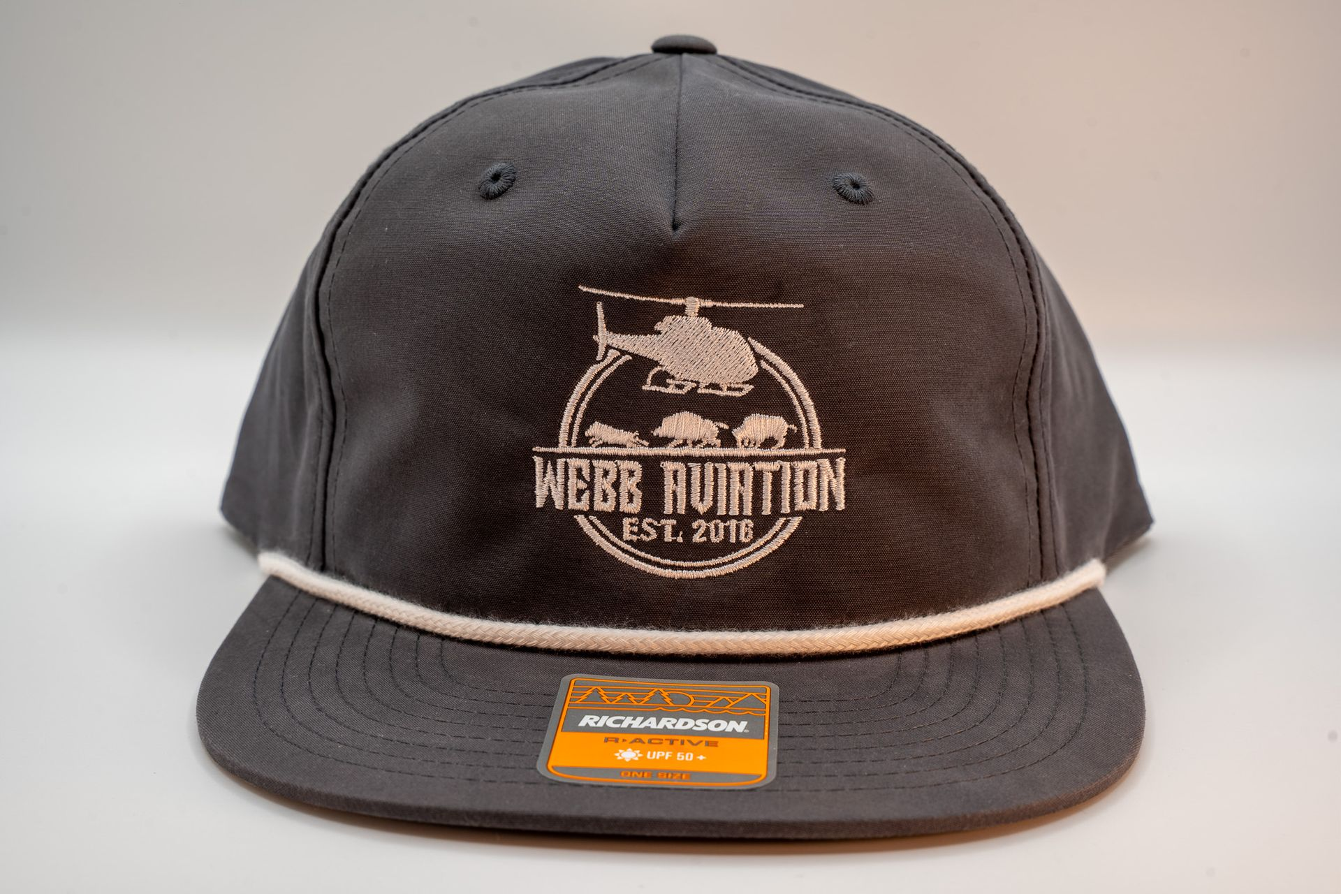 Black baseball cap with white logo and orange sticker on the brim, shown on a light background