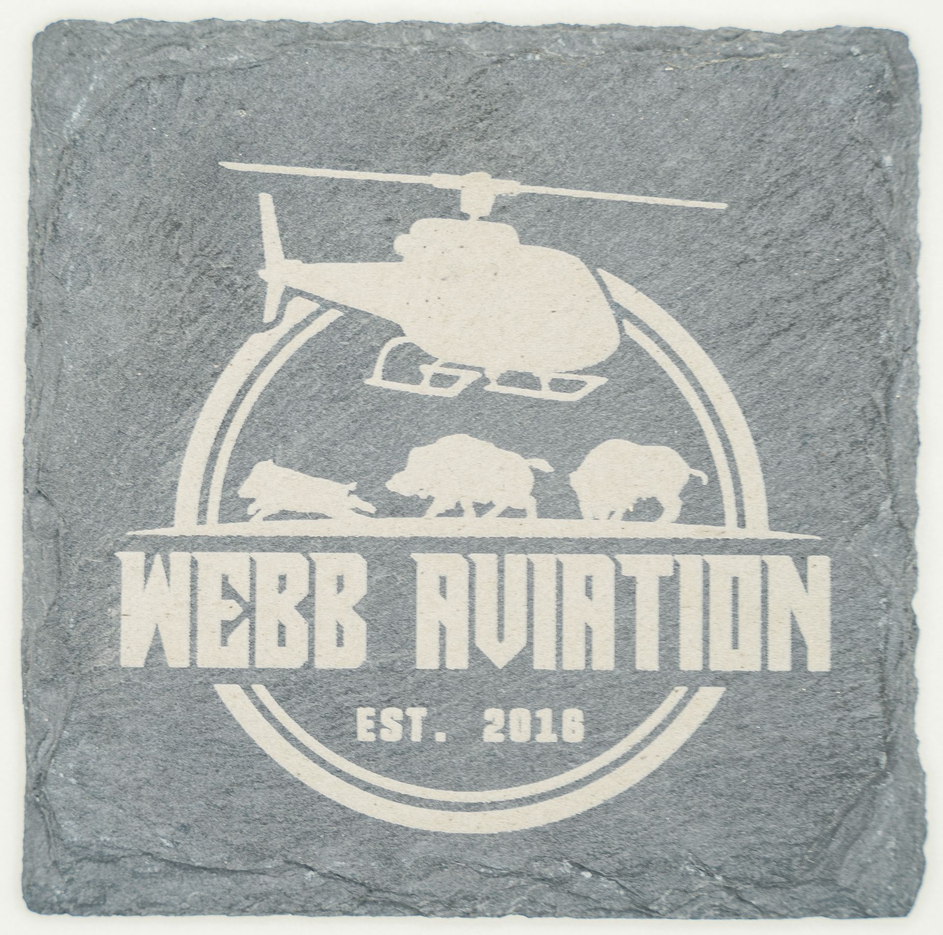 White “Webb Aviation” logo with helicopter and bear silhouettes on a gray stone tile.