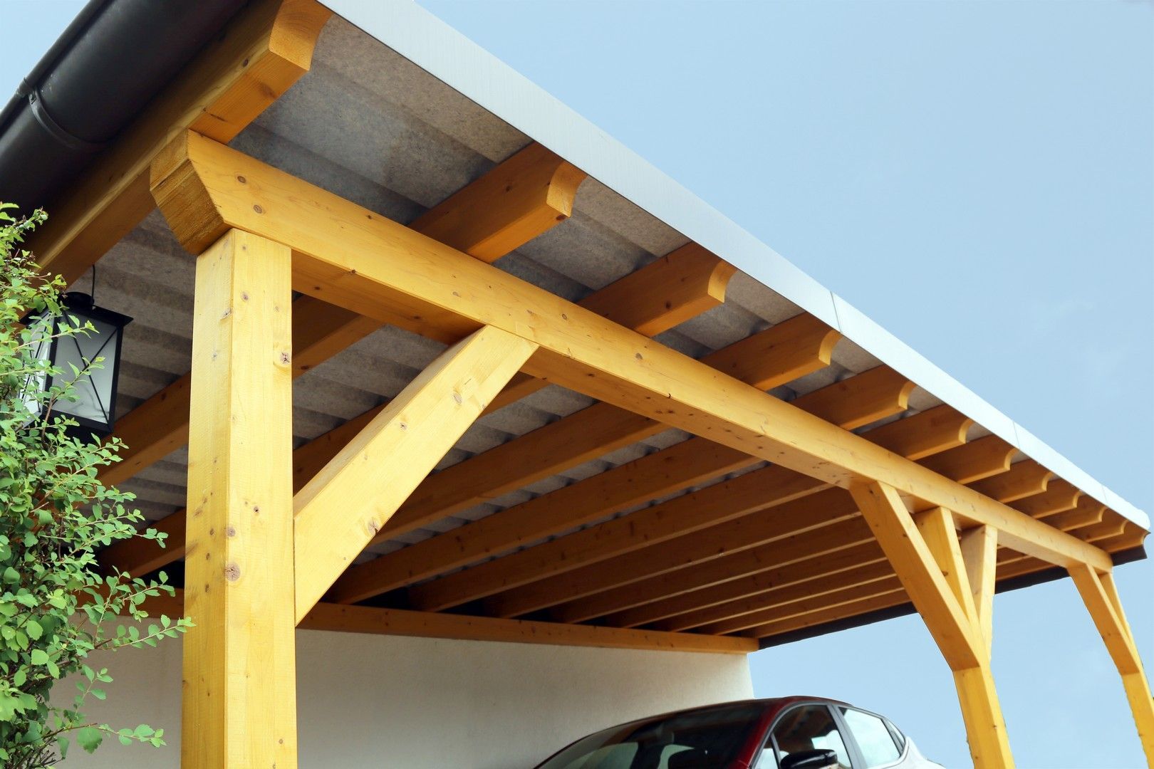 Un'auto è parcheggiata sotto una struttura di legno
