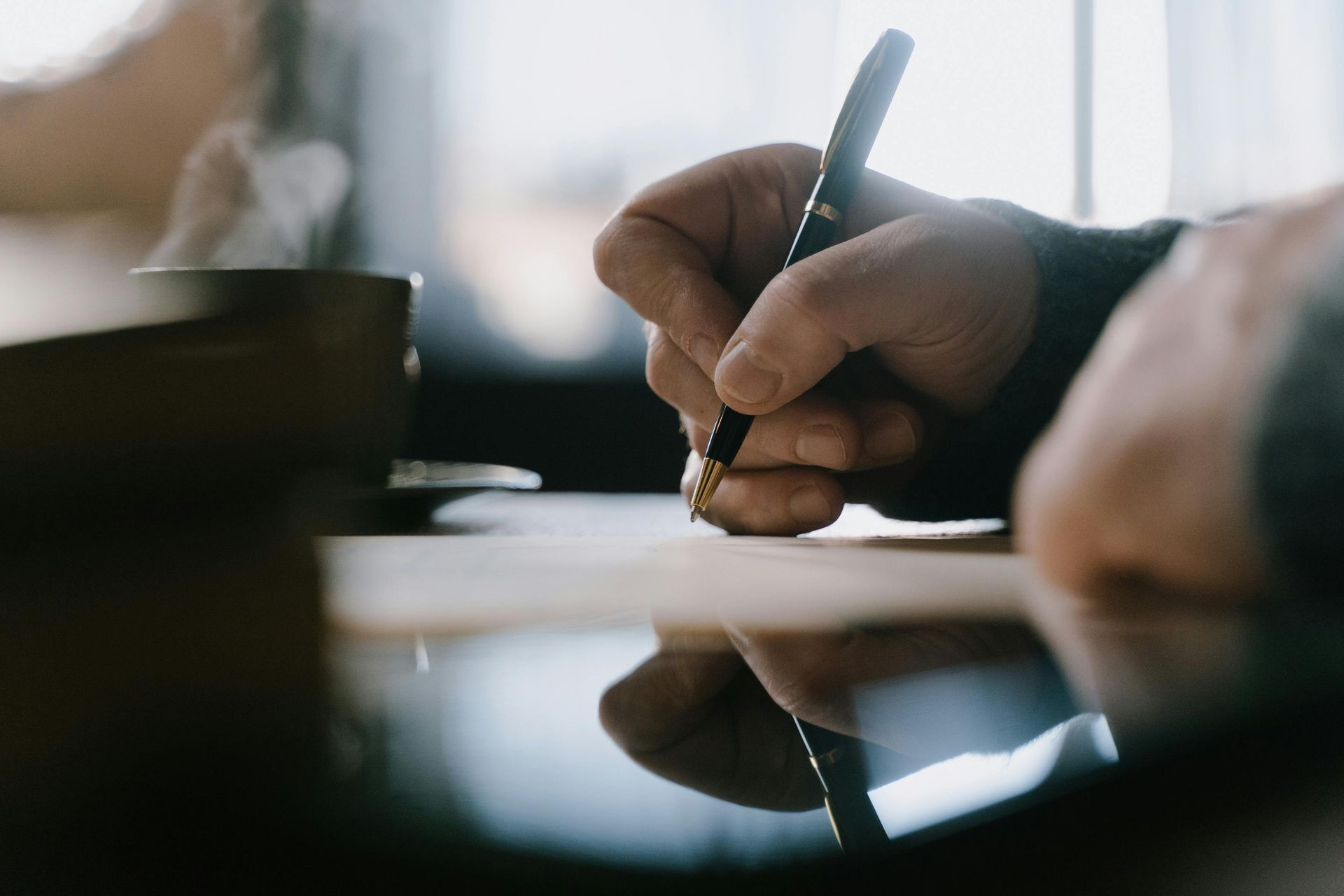Male hand signing documents as an outsourced CFO Advisor