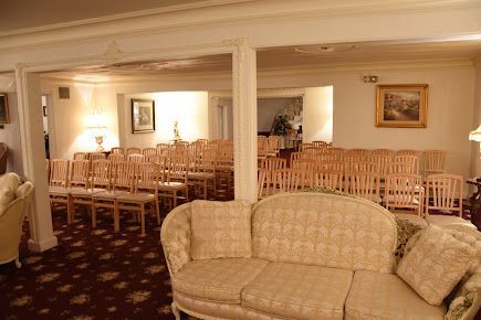 There is a couch in the middle of a room with chairs.