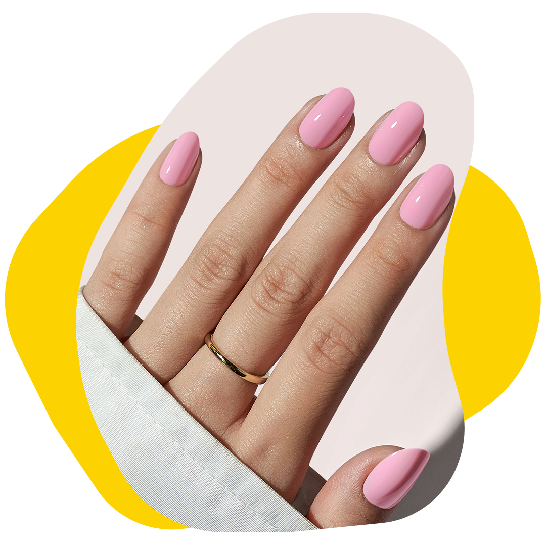 Hand with oval-shaped, light pink painted nails, a gold ring, and a white sleeve, against a yellow and pink background.