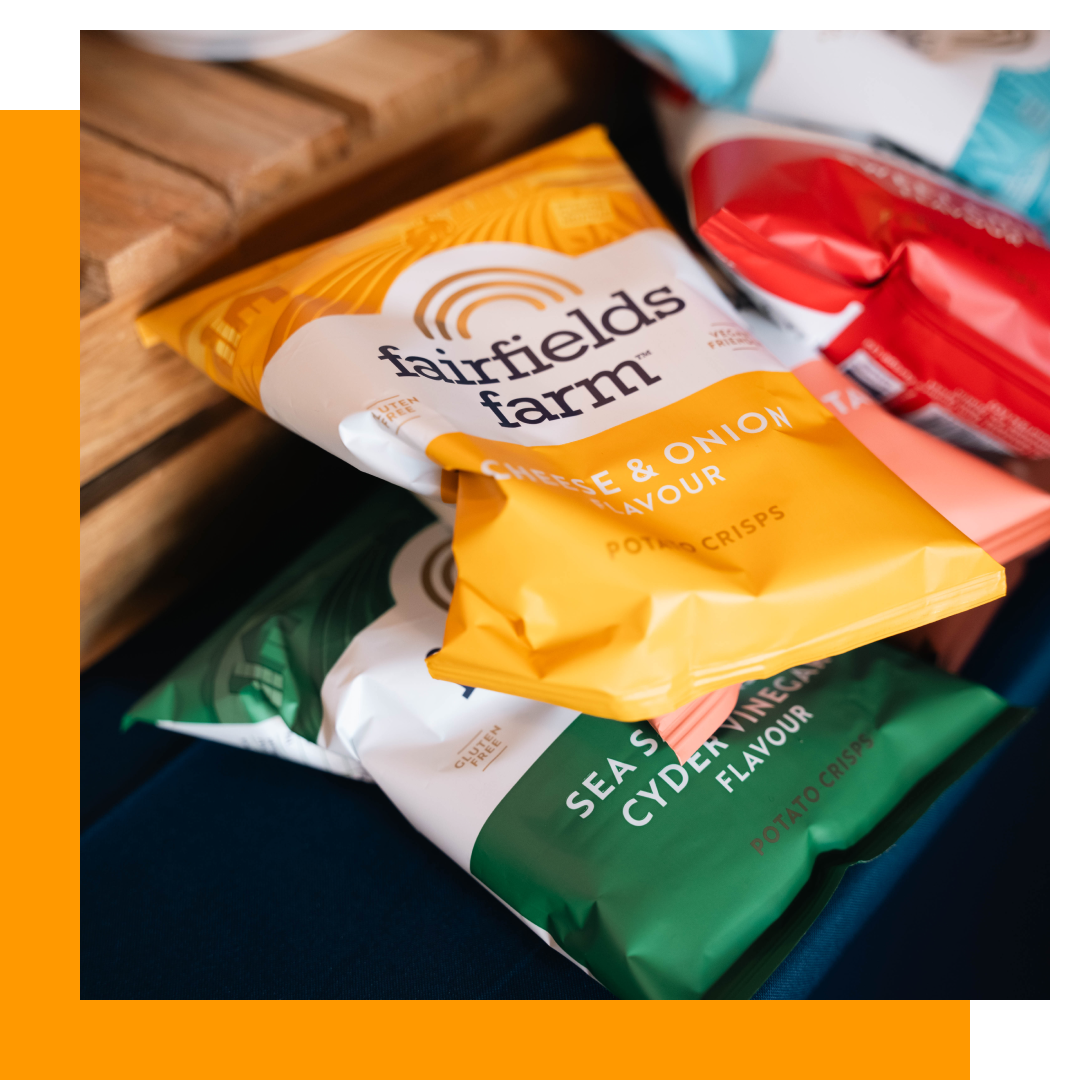 Bags of Fairfield Farm potato crisps: Cheese & Onion, Sea Salt & Cider Vinegar, and red packaging.