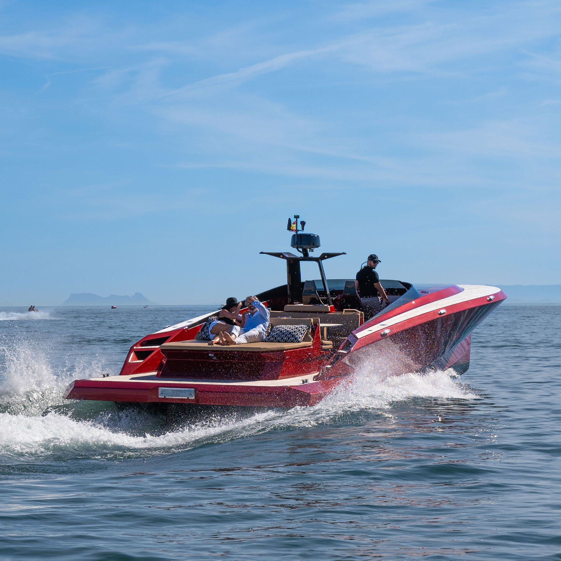 High-speed red yacht creating waves during a charter tour near Marbella