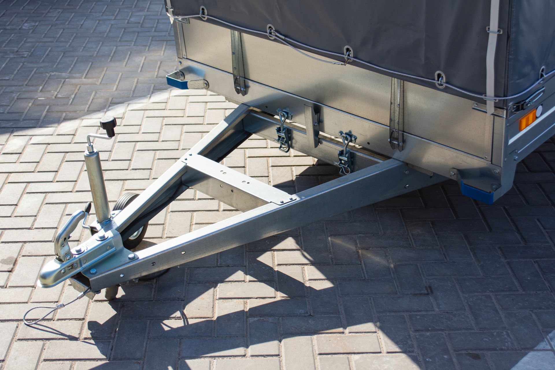 Trailer hitch with a metal tow bar on a paved surface