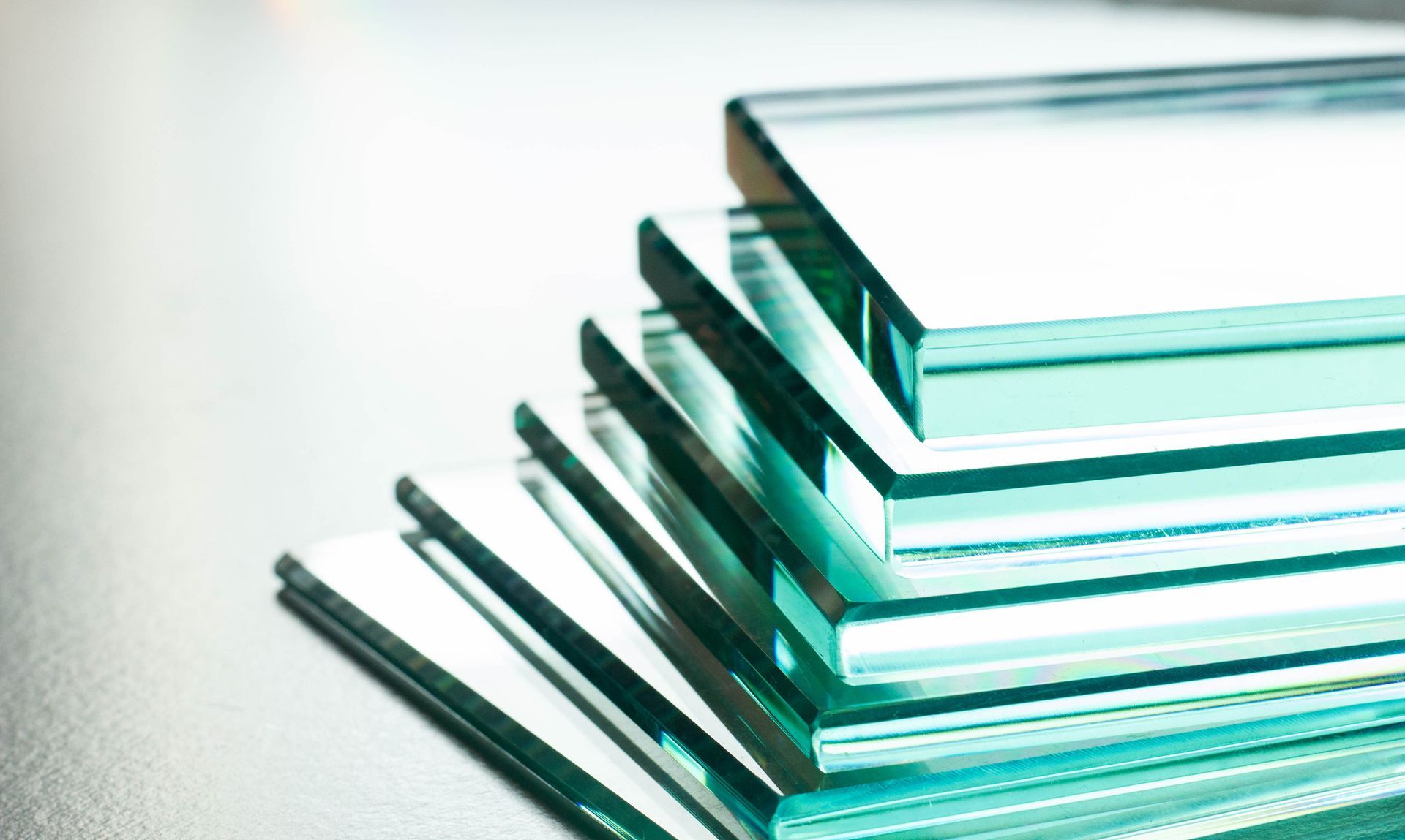 Stack of clear glass sheets arranged neatly on a light surface. Stack of clear glass sheets arranged neatly on a light surface.