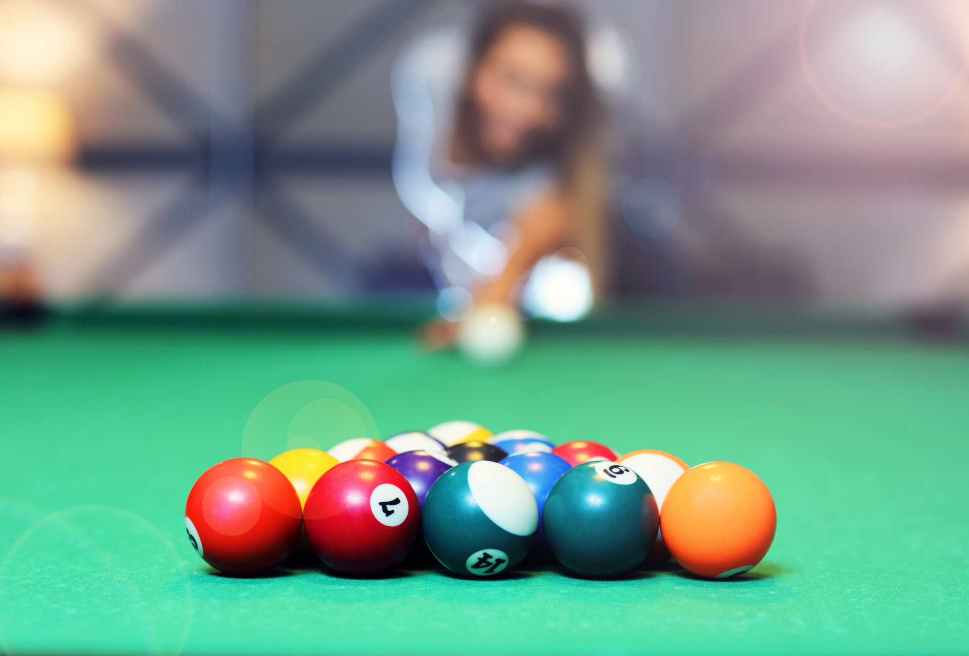 A woman is playing pool on a pool table.