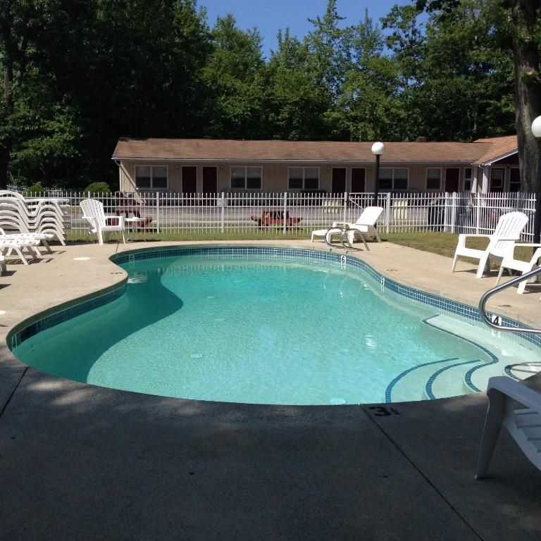a large swimming pool surrounded by chairs and a fence
