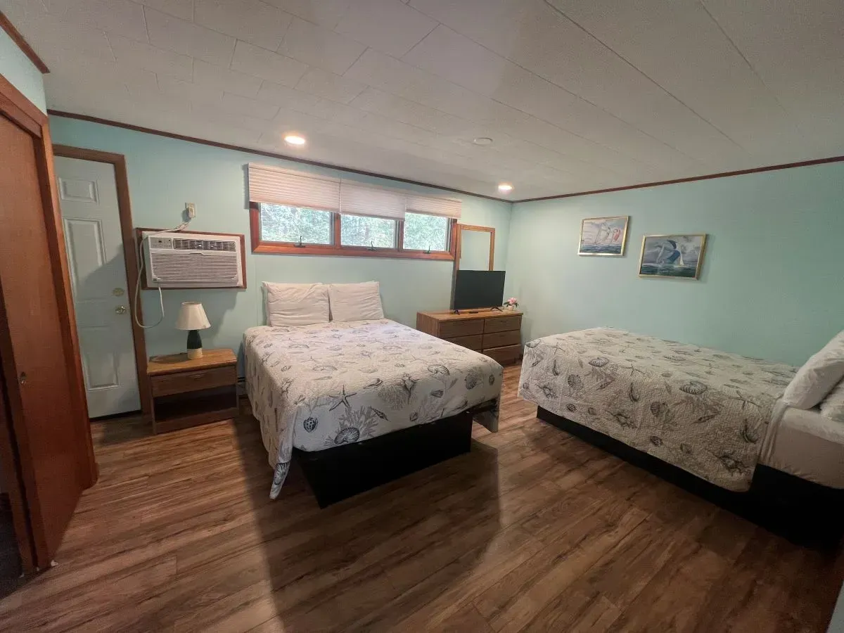 A bedroom with two beds and a television.