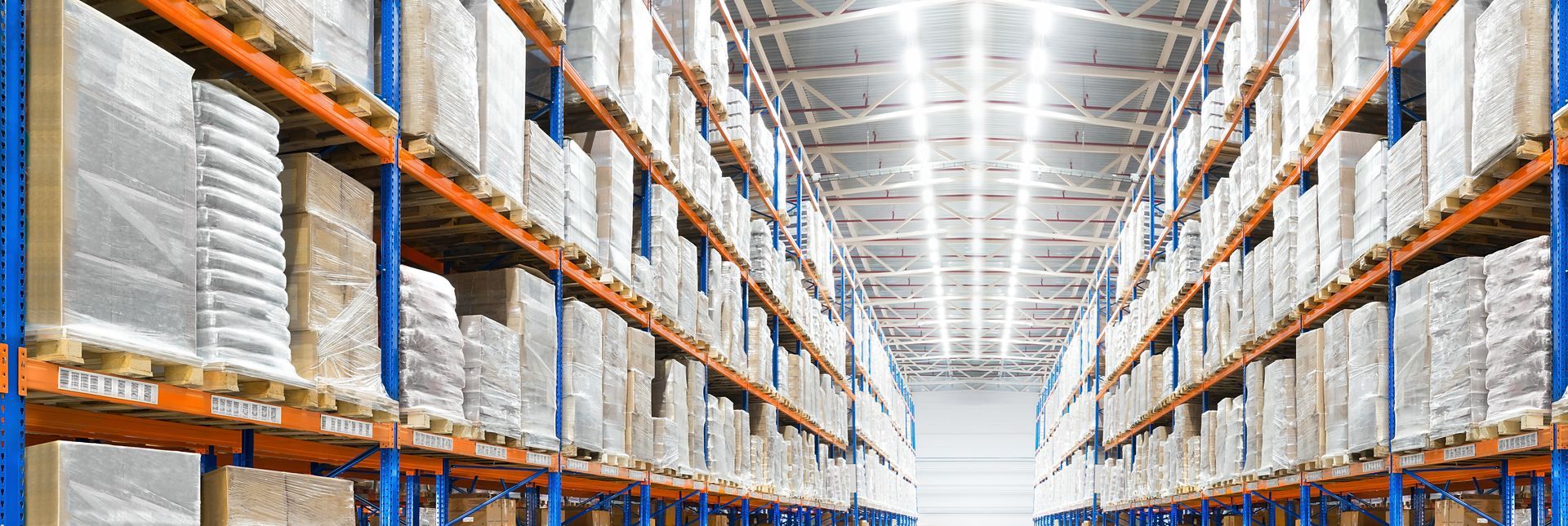 Warehouse interior with rows of shelves stacked with boxes.