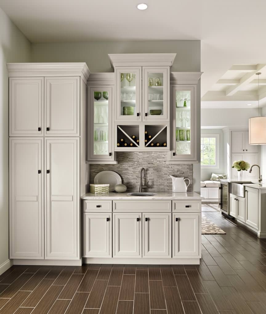 A kitchen with white cabinets , a sink , and a wine rack.