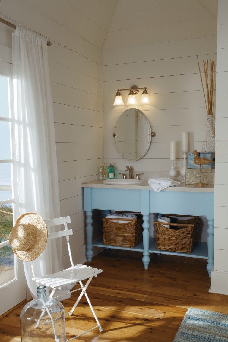 A bathroom with two sinks , a mirror and a chair.