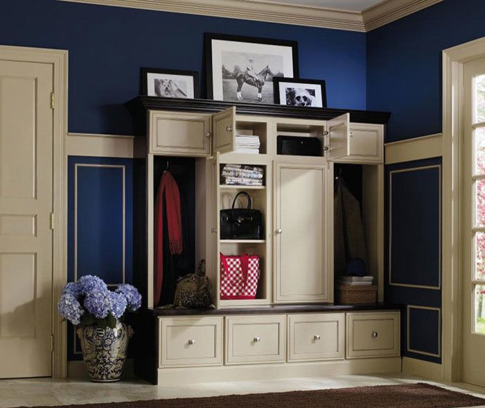 A room with blue walls and white cabinets and drawers