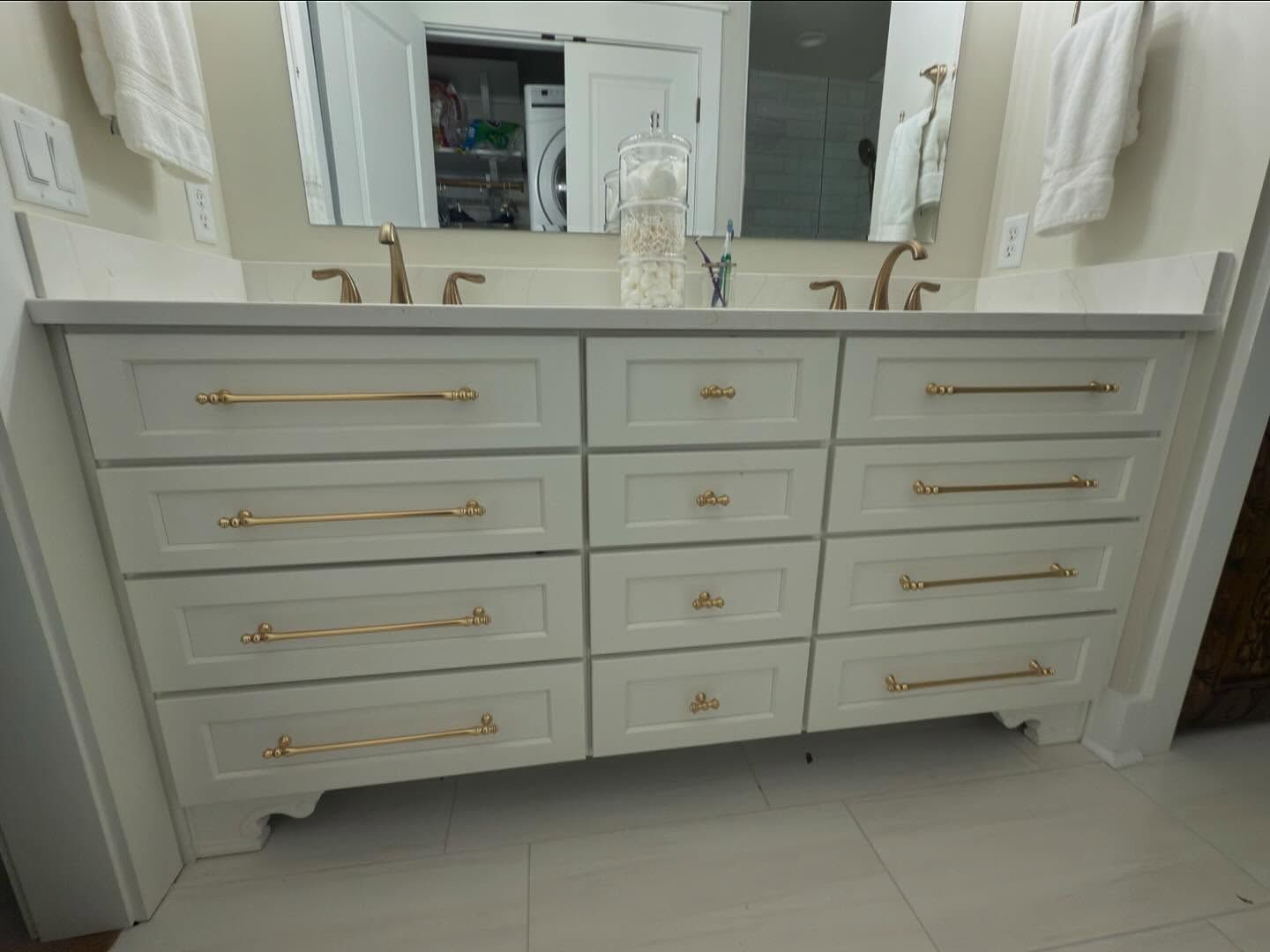 Bathroom with wooden vanity, toilet, and basket of towels.