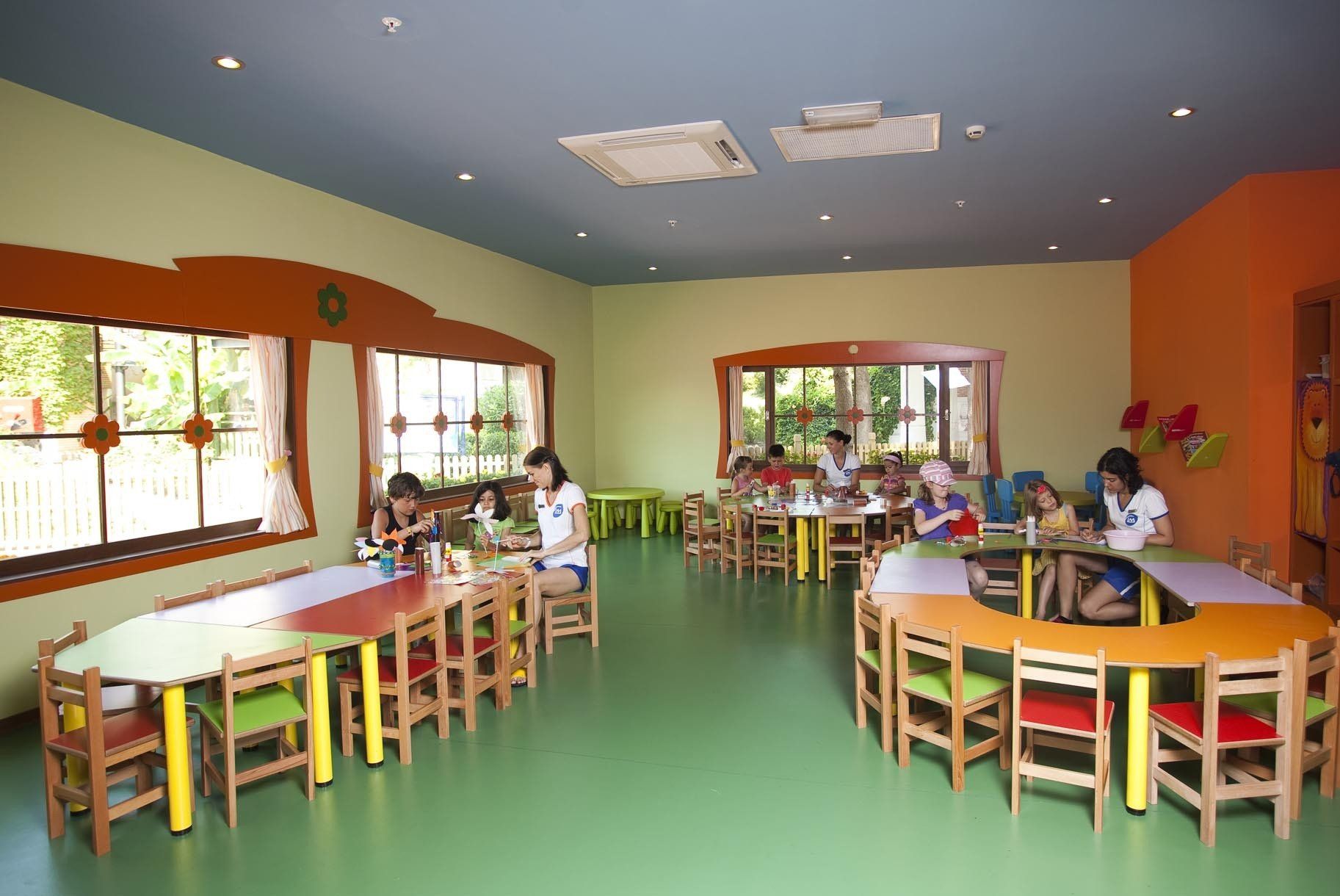 Un groupe d'enfants sont assis à des tables dans une salle de classe.
