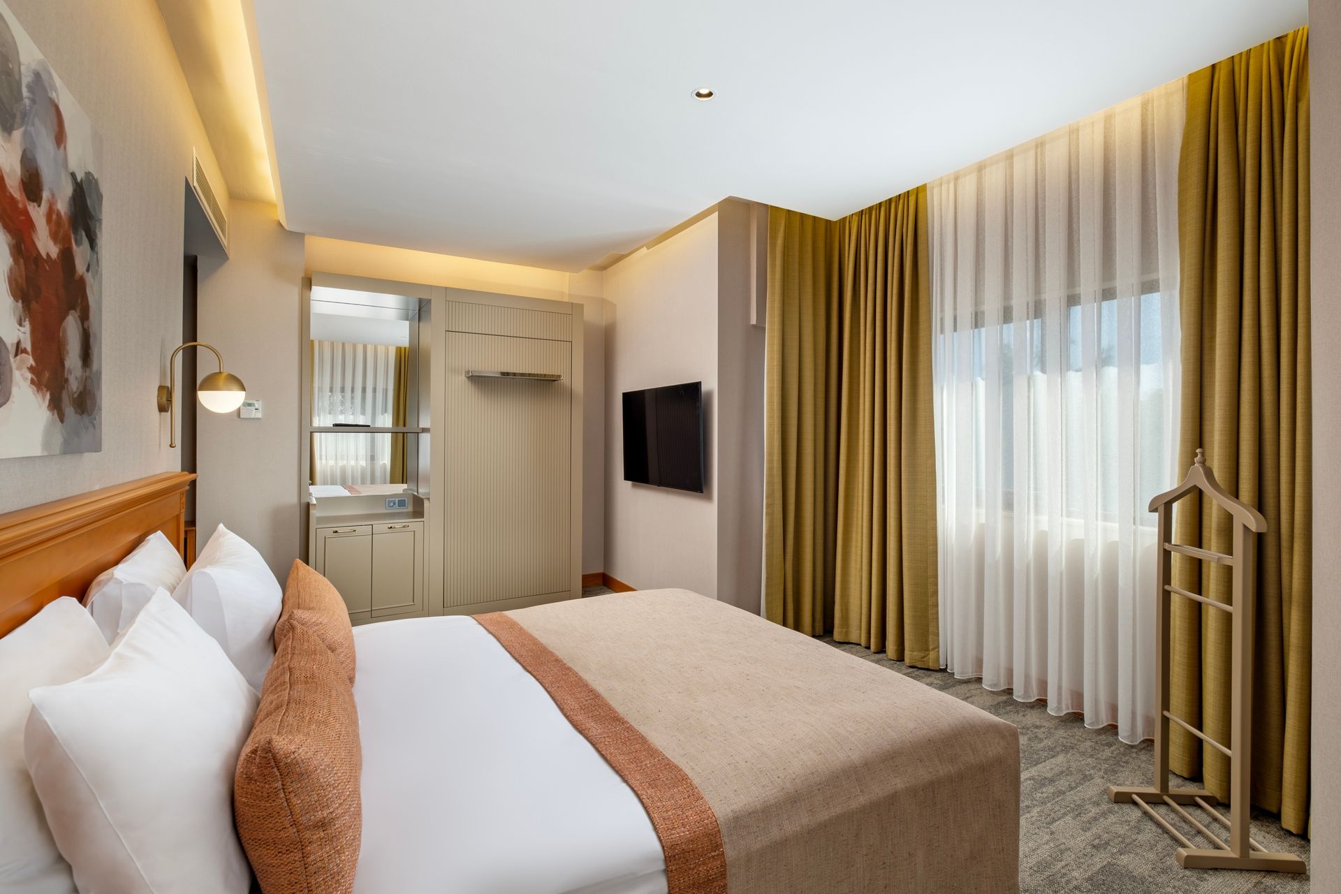 A hotel room with a king size bed and a television.