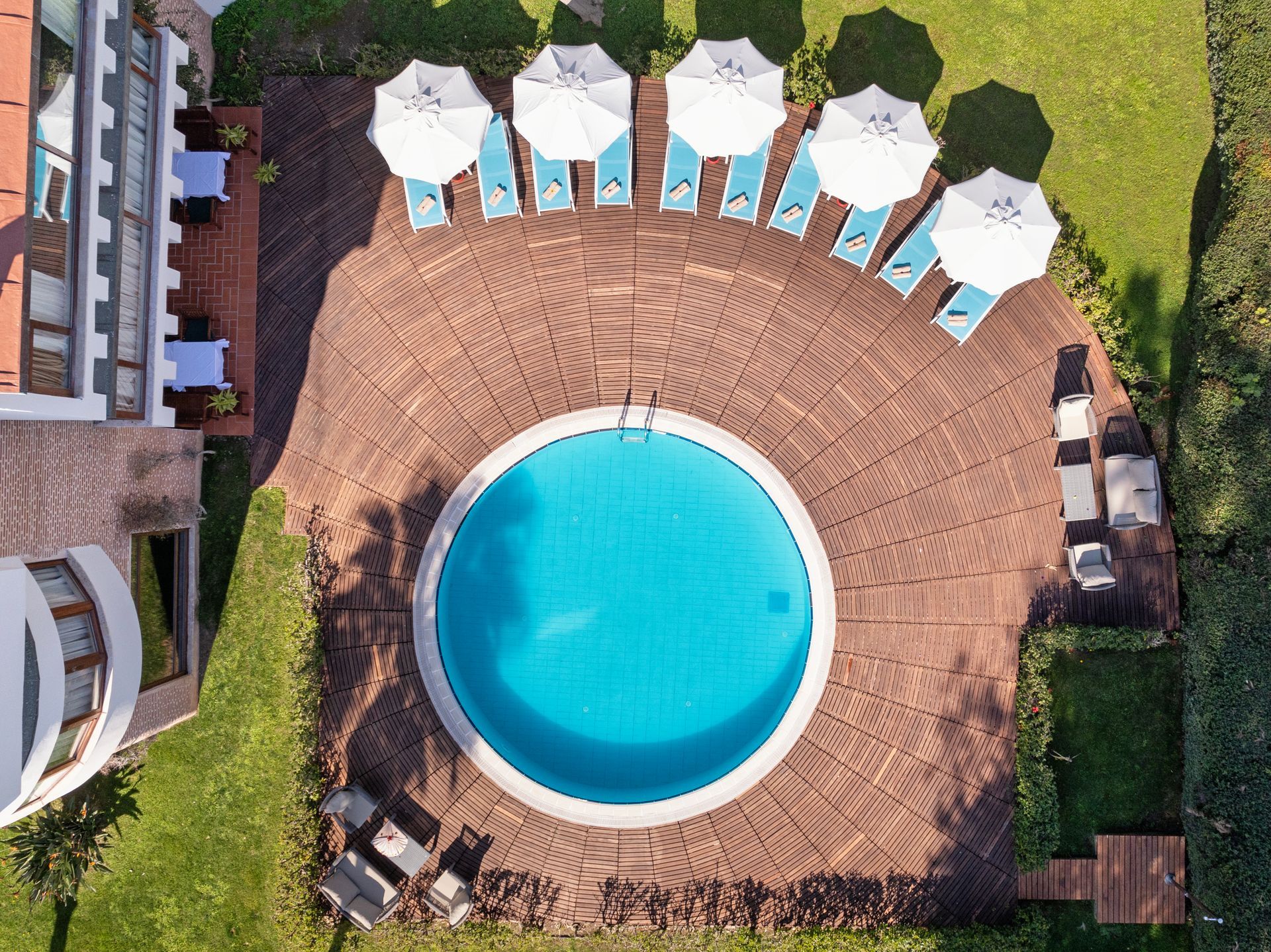 An aerial view of a swimming pool surrounded by chairs and umbrellas