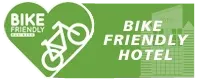 A green sign that says bike friendly hotel with a bicycle in a heart.