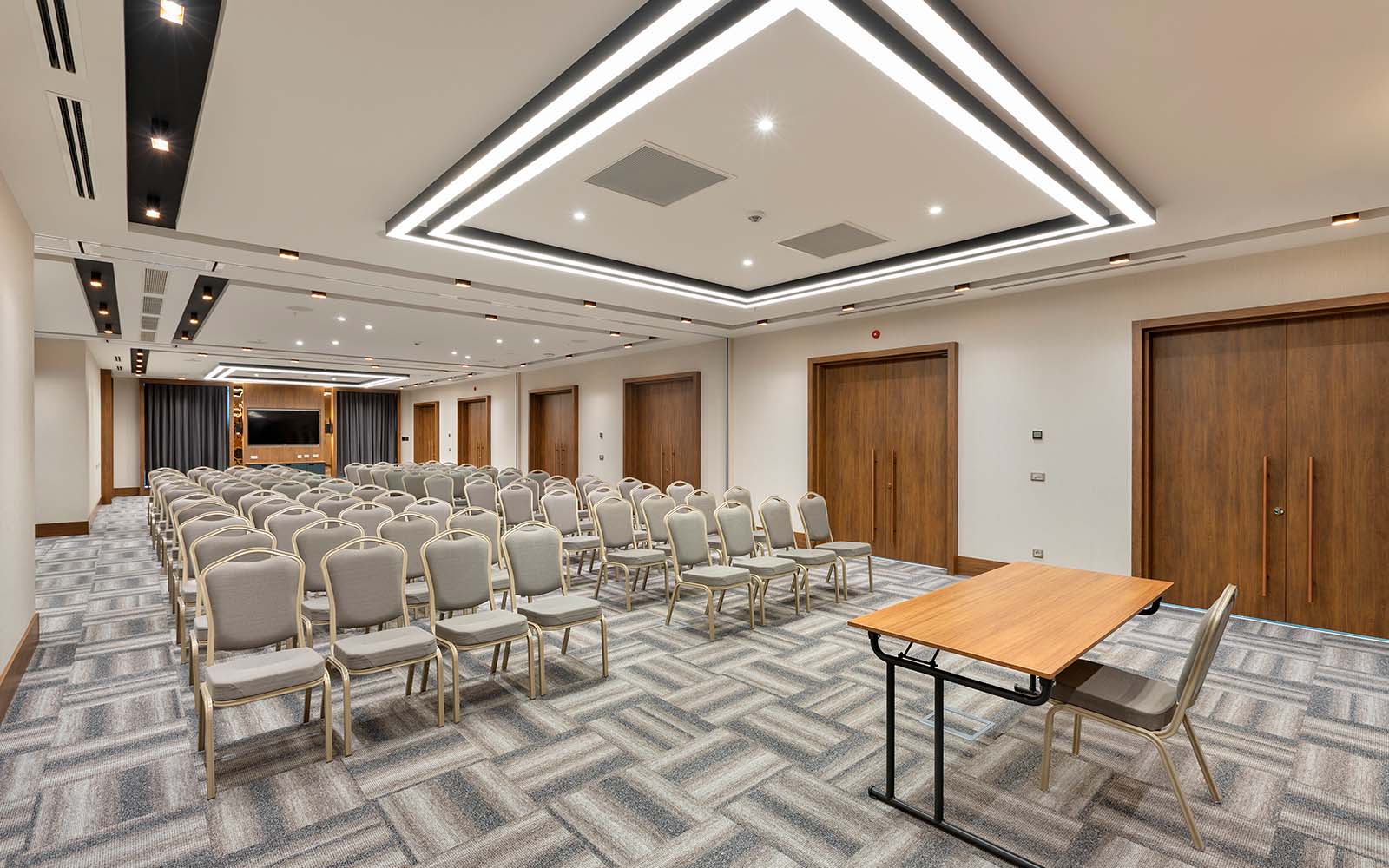 A large conference room with rows of chairs and a table.
