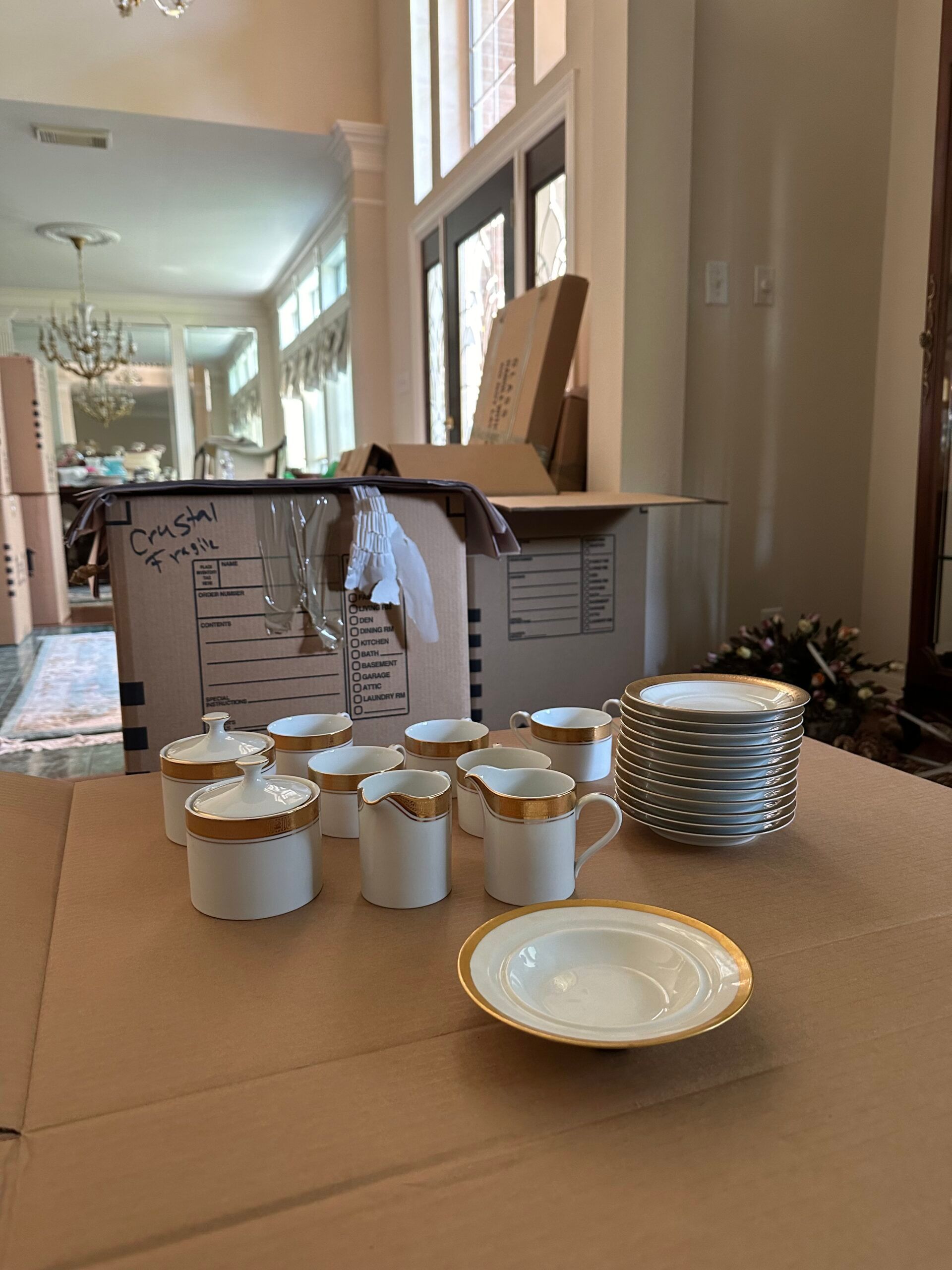 Fine china laid out on packing paper before being boxed by Veteran's Best Movers