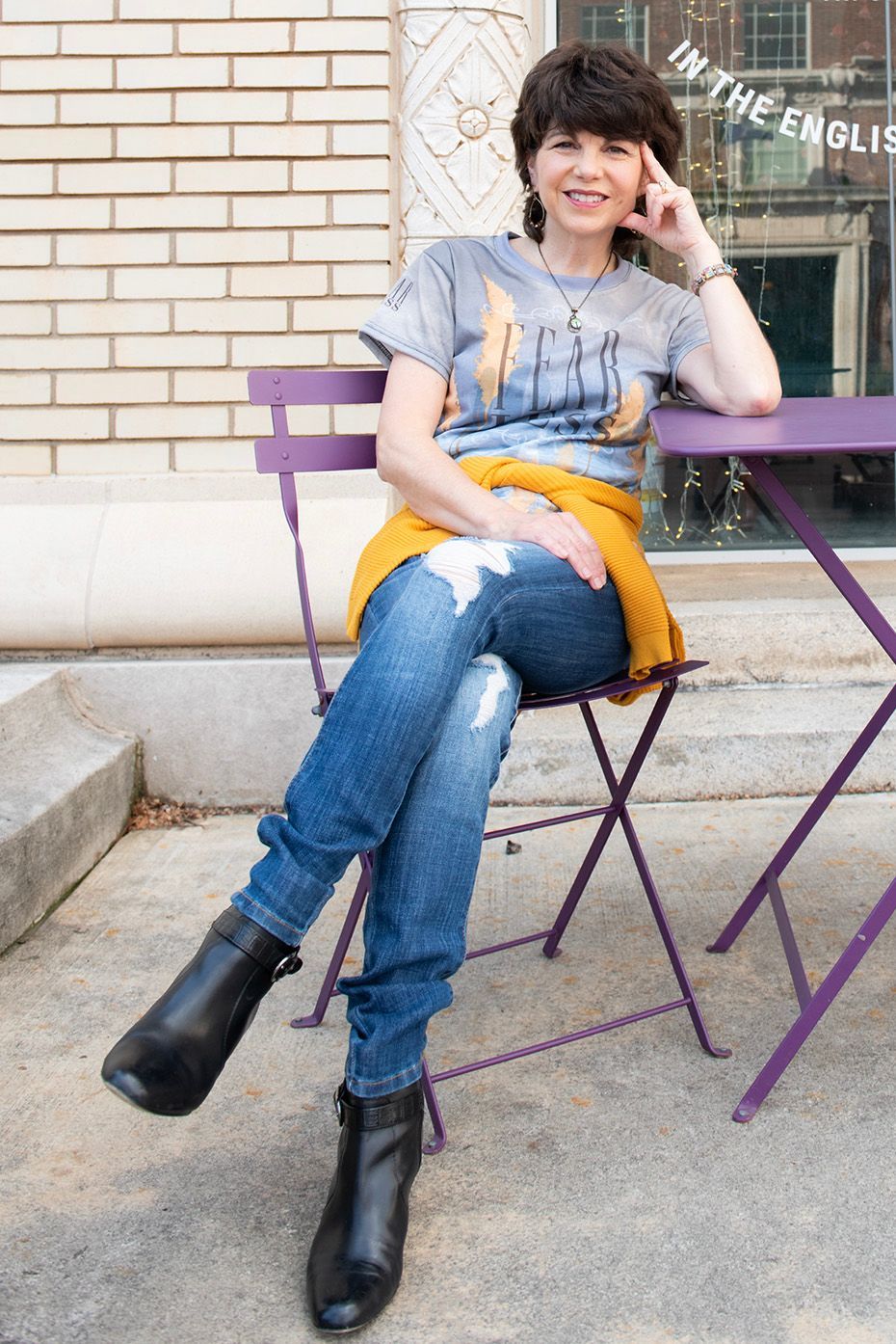 A woman is sitting at a table with a sign that says in the eagles