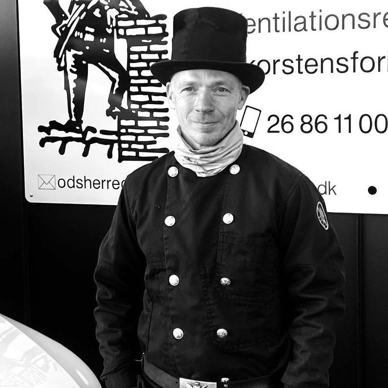 Et sort/hvidt foto af en mand iført høj hat