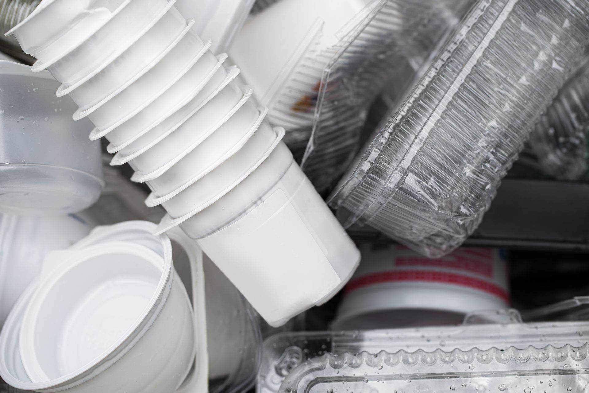 A pile of plastic cups and containers are stacked on top of each other.