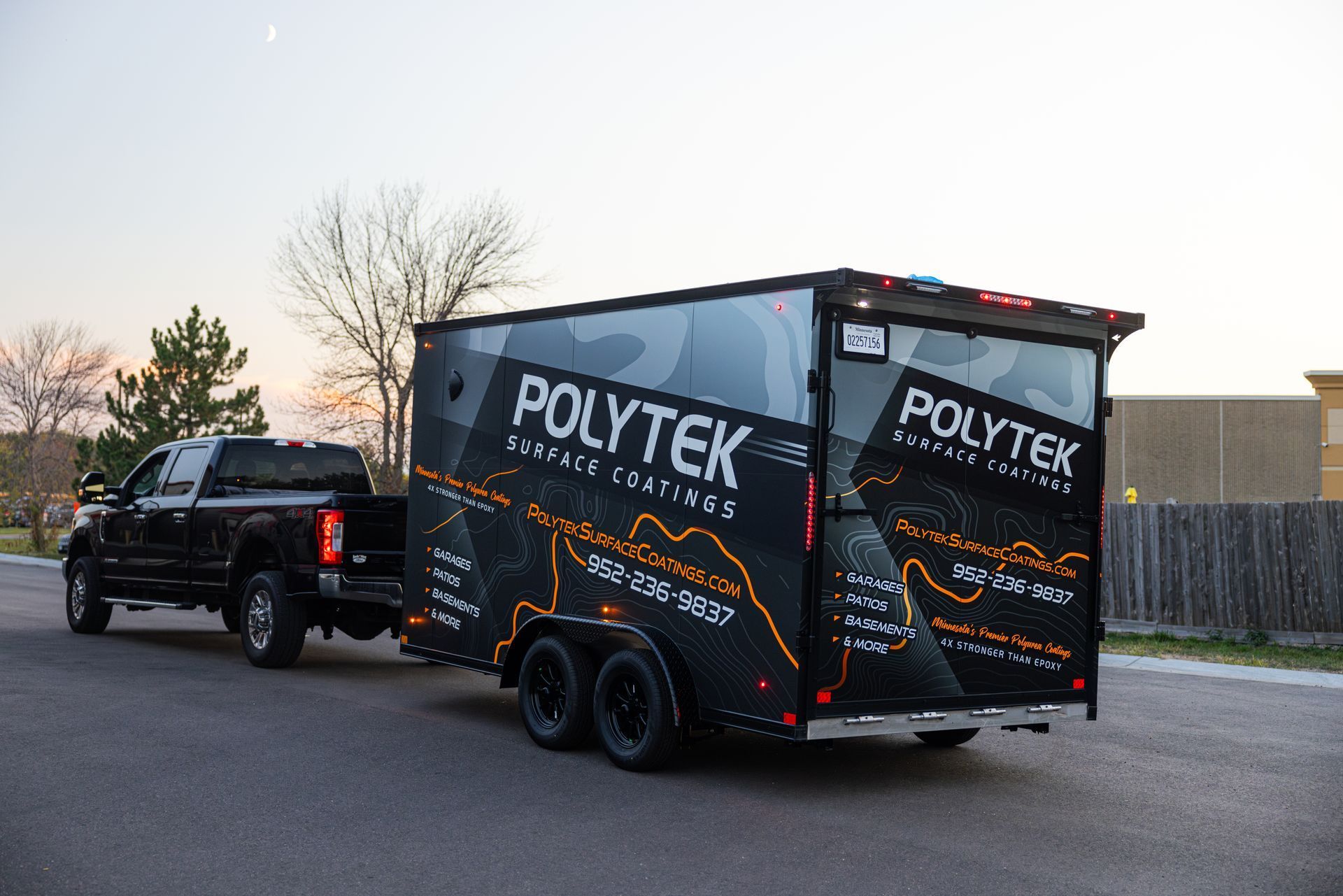 A truck is pulling a trailer that says polytek on it.