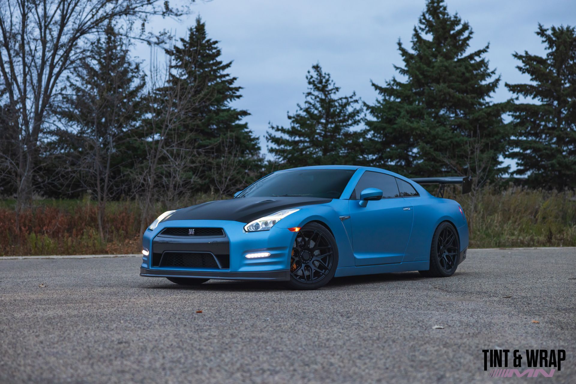A blue sports car is parked on the side of the road.