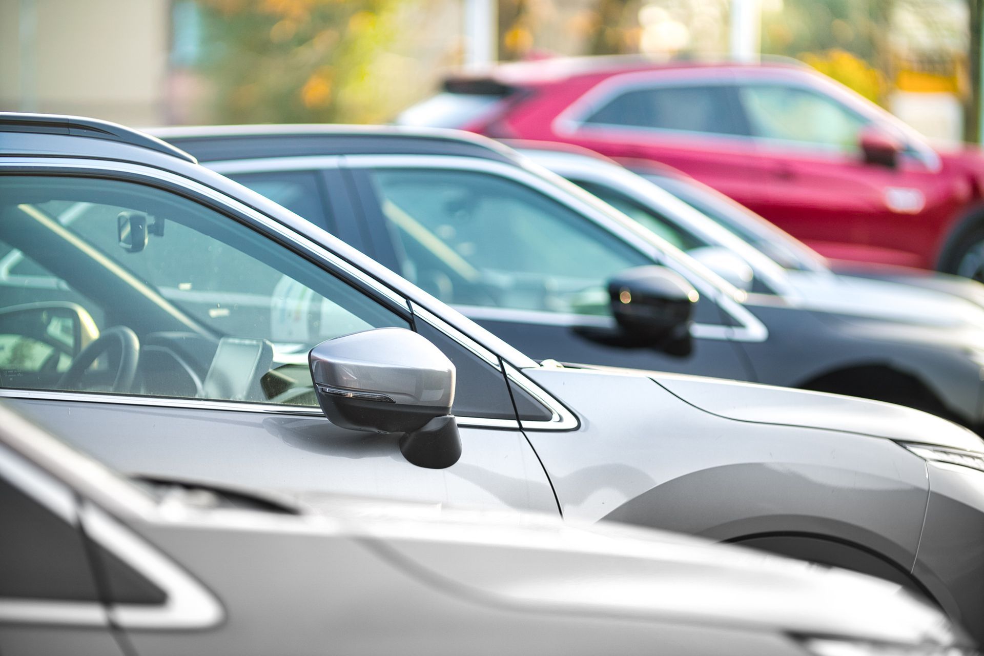 A row of cars are parked next to each other in a parking lot.