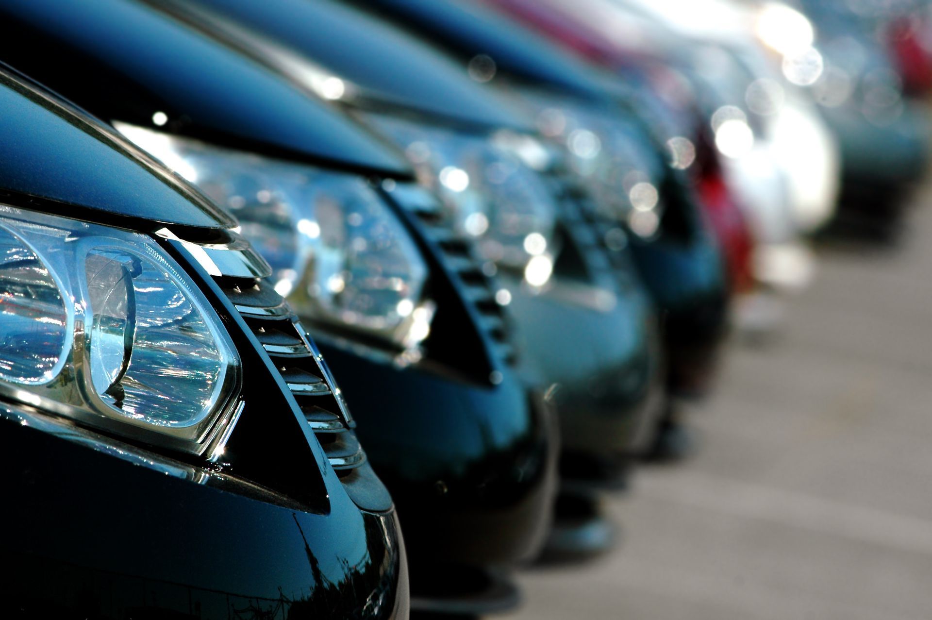 A row of cars are parked next to each other in a parking lot.