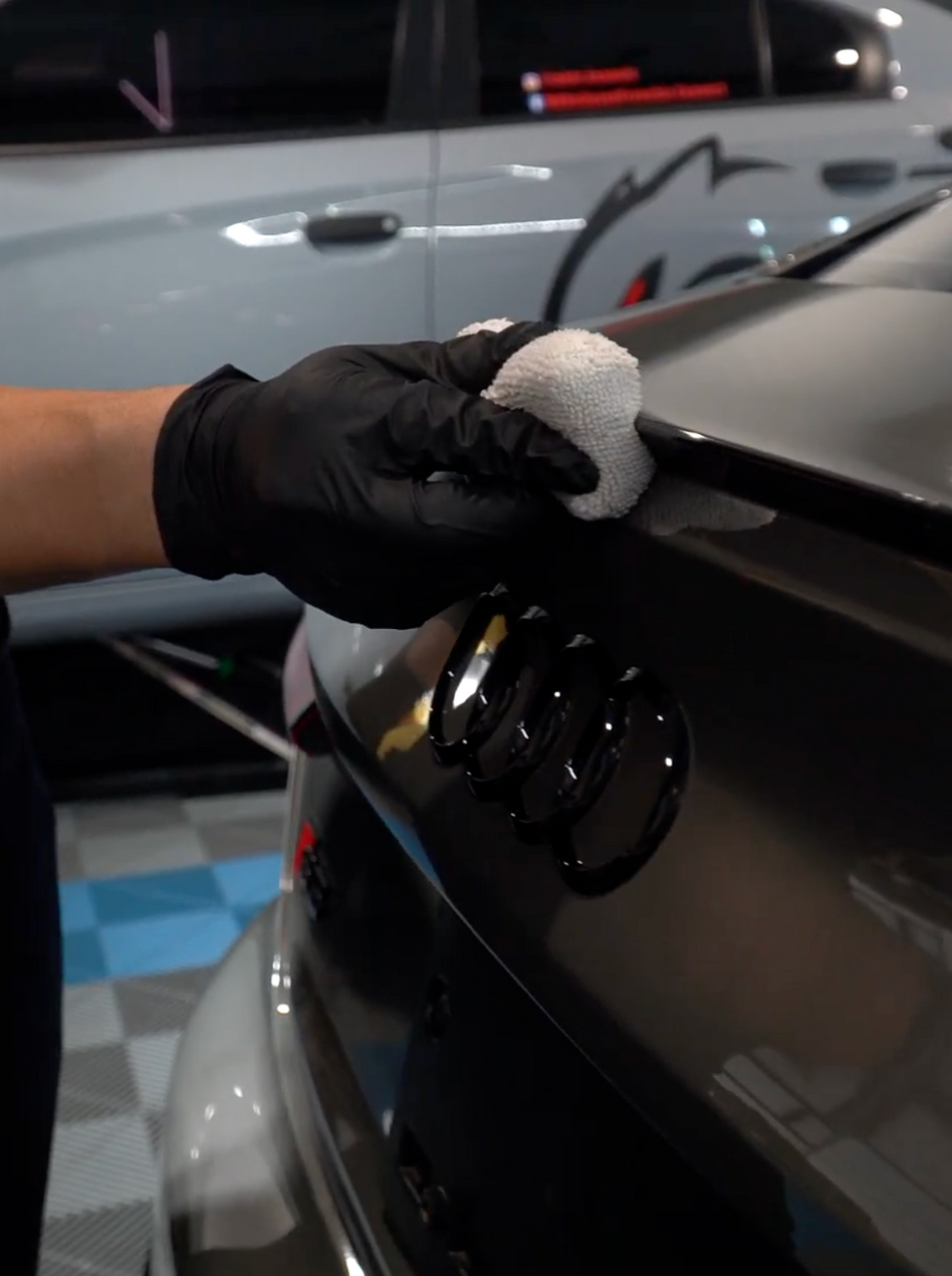 A person is polishing a blue car with a ceramic coating. A person is polishing a blue car with a ceramic coating.