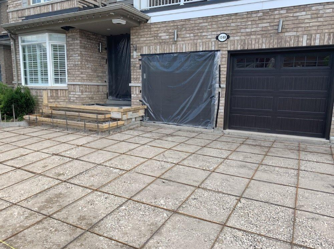 “Large concrete paver driveway leading to a home with brick accents and garage doors during concrete services in Pine Hills, FL”