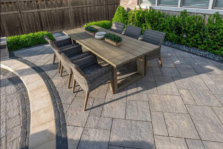 “Outdoor dining area with gray concrete pavers arranged around a patio table during concrete services in Pine Hills, FL”