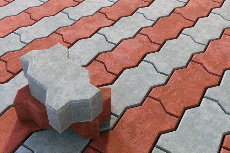 “Red and gray interlocking concrete pavers with a loose block placed on top during concrete services in Pine Hills, FL”