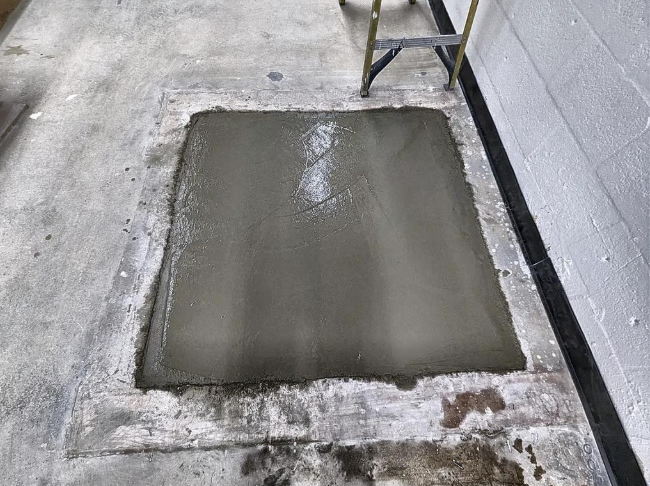 “Fresh square concrete patch repaired in a damaged floor area during concrete services in Pine Hills, FL”