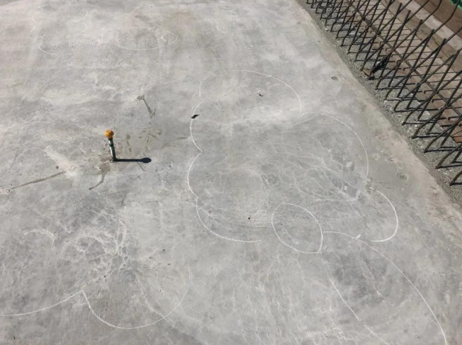 “Cracked concrete surface marked for repair near a metal fence during concrete services in Pine Hills, FL”